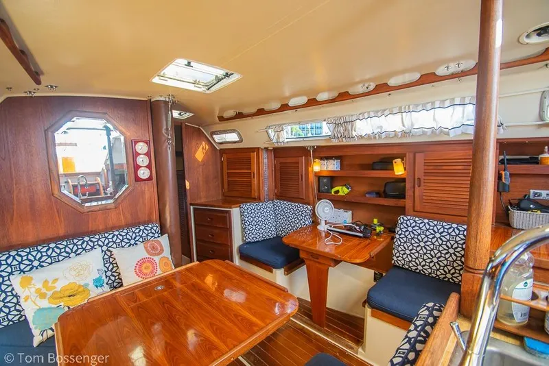 Slide: The Image of Interior of 1985 Catalina 36 sailboat with wooden furnishings and patterned cushions. - 12