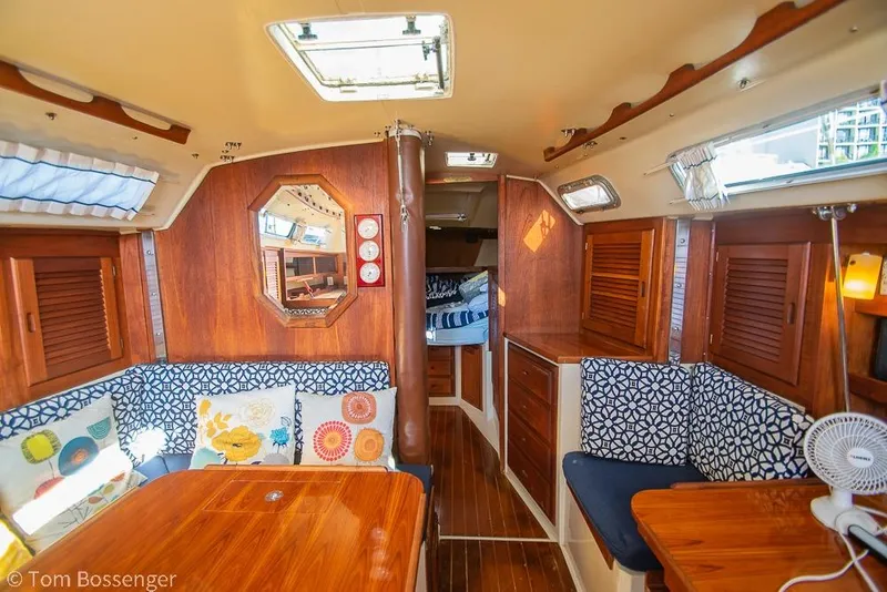Slide: The Image of Interior of a 1985 Catalina 36 sailboat with wooden furnishings and patterned cushions. - 13