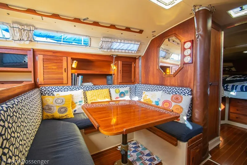 Slide: The Image of Interior of 1985 Catalina 36 sailboat with cozy dining area and colorful cushions. - 14