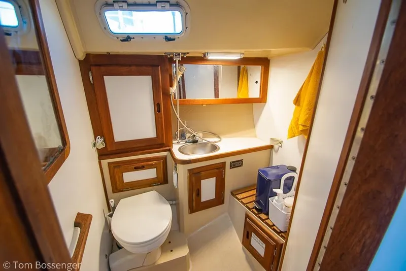 Slide: The Image of Interior of 1985 Catalina 36 sailboat bathroom with sink, toilet, and wooden cabinetry. - 21