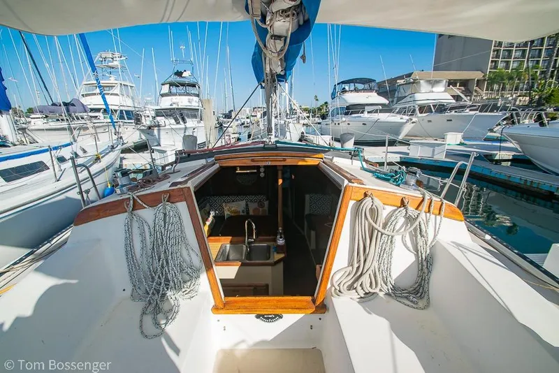 Slide: The Image of 1985 Catalina 36 sailboat docked in marina, showcasing cockpit and interior cabin. - 4