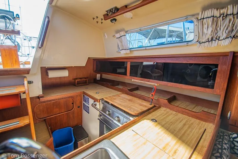 Slide: The Image of Interior of a 1985 Catalina 36 sailboat galley with wooden cabinetry and appliances. - 9