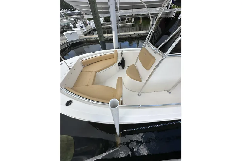 Slide: The Image of 2019 Cobia 220 Center Console boat with tan seating, docked in a marina. - 3