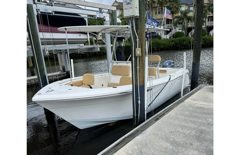 Slide: The Image of 2019 Cobia 220 Center Console boat docked by waterfront homes. - 4