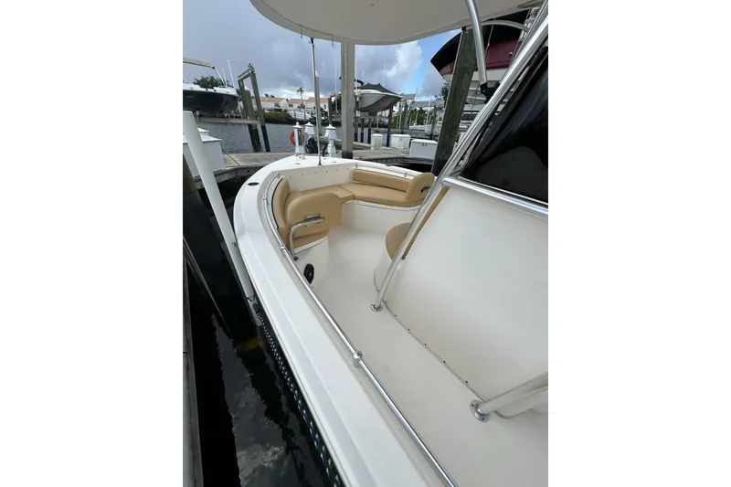 Slide: The Image of 2019 Cobia 220 Center Console boat docked, featuring spacious seating and sleek design. - 5