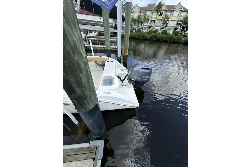 Slide: The Image of 2019 Cobia 220 Center Console boat docked with Yamaha outboard motor. - 6
