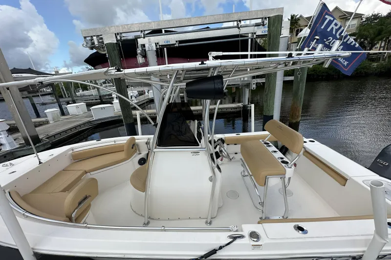 Slide: The Image of 2019 Cobia 220 Center Console boat docked, featuring tan seating and sleek design. - 9