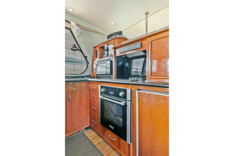 Slide: The Image of Kitchen area of 2004 Carver 570 Voyager Pilothouse with wooden cabinetry and modern appliances. - 19