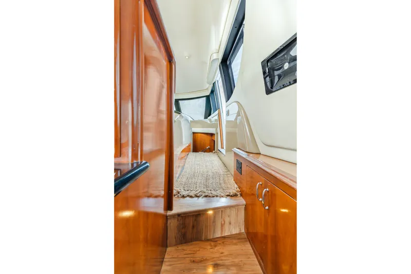 Slide: The Image of Interior view of 2004 Carver 570 Voyager Pilothouse, featuring wood finishes and carpeted walkway. - 21
