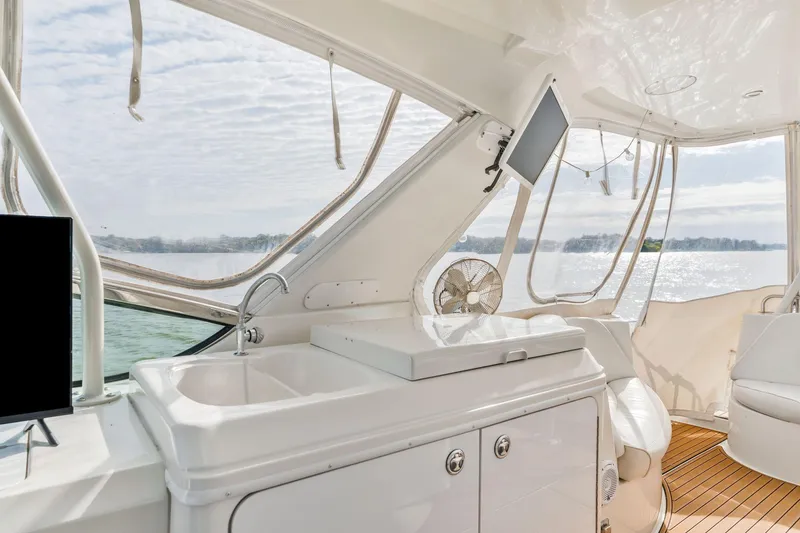 Slide: The Image of Interior of 2004 Carver 570 Voyager Pilothouse with sink, seating, and scenic water view. - 46