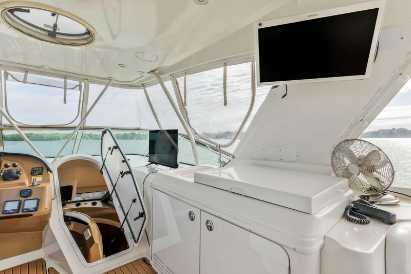 Slide: The Image of 2004 Carver 570 Voyager Pilothouse interior with helm, screens, and fan. - 51