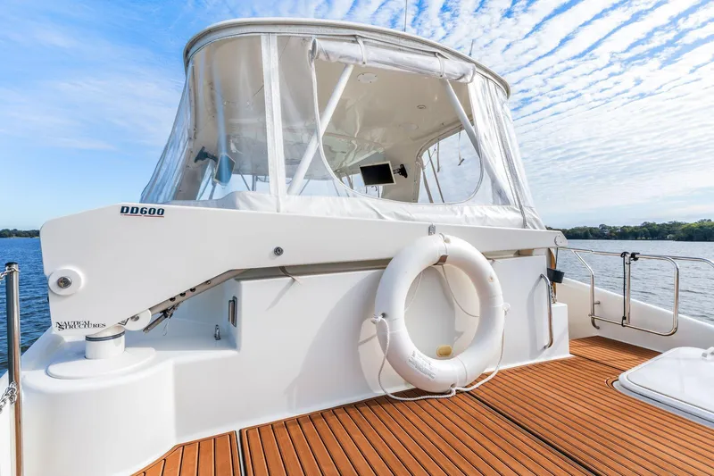 Slide: The Image of 2004 Carver 570 Voyager Pilothouse yacht with teak deck and lifebuoy, under a clear sky. - 55