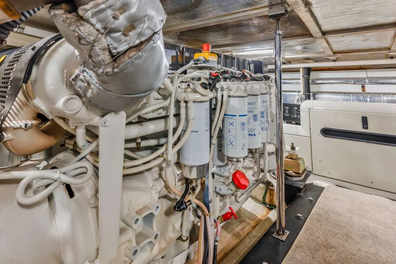 Slide: The Image of Engine room of 2004 Carver 570 Voyager Pilothouse, showcasing detailed machinery components. - 70