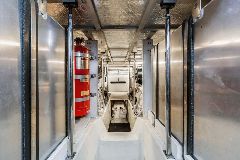 Slide: The Image of Engine room of 2004 Carver 570 Voyager Pilothouse with fire extinguisher and metallic surfaces. - 73