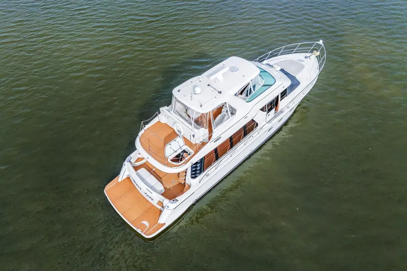 Slide: The Image of 2004 Carver 570 Voyager Pilothouse yacht on calm water, aerial view. - 8