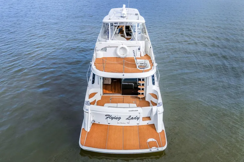 Slide: The Image of 2004 Carver 570 Voyager Pilothouse yacht on calm water, rear view. - 9