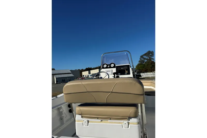 Slide: The Image of 2019 NauticStar 211 Hybrid boat interior with tan seating and control panel. - 3