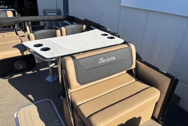 Slide: The Image of 2026 Barletta C24UE boat interior with beige seating and table. - 7