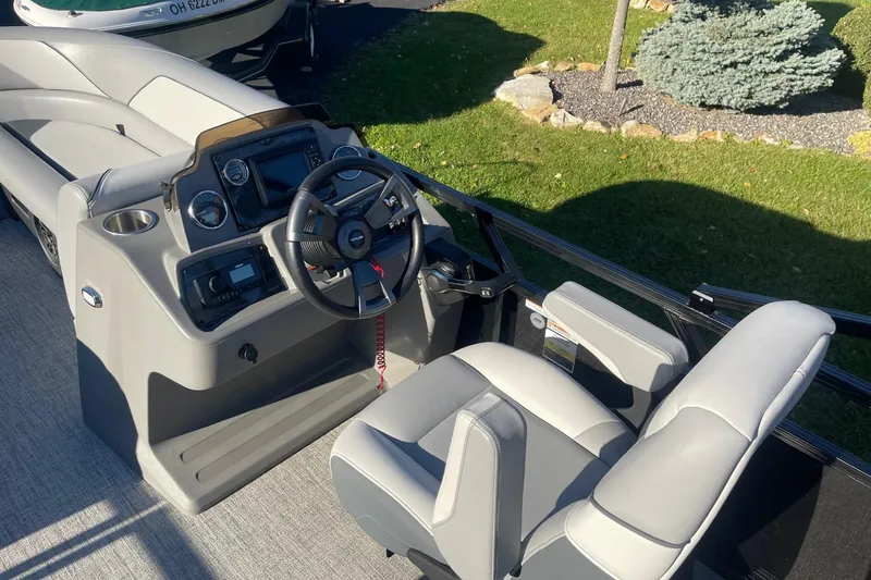 Slide: The Image of 2025 Avalon Venture 2585 VRB boat interior with sleek gray seating and cup holders. - 18