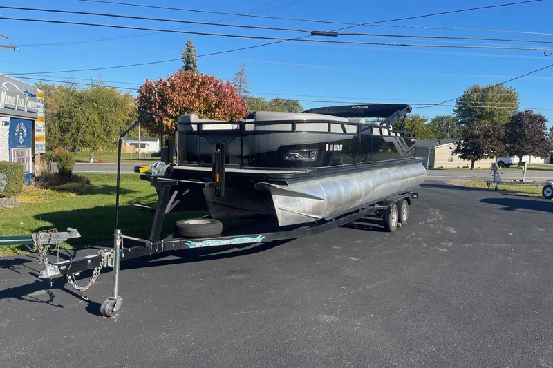 Slide: The Image of 2025 Avalon Venture 2585 VRB pontoon boat on trailer in sunny outdoor setting. - 2