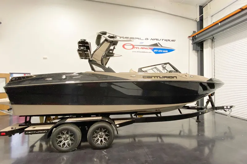 Slide: The Image of 2025 Centurion Fe22 boat on trailer in showroom setting. - 2
