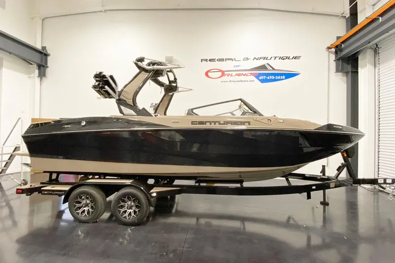 Slide: The Image of 2025 Centurion Fe22 boat on trailer in showroom, side view. - 3
