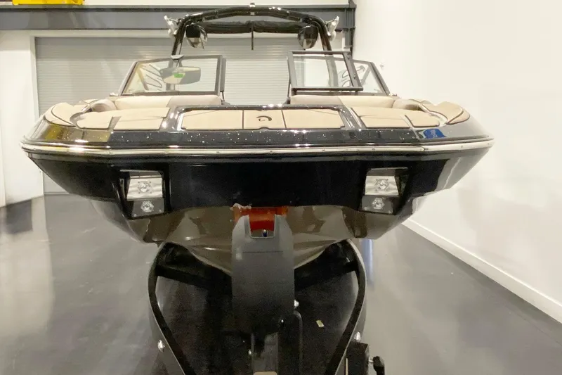 Slide: The Image of 2025 Centurion Fe22 boat in showroom, front view, sleek design, black and beige color scheme. - 5