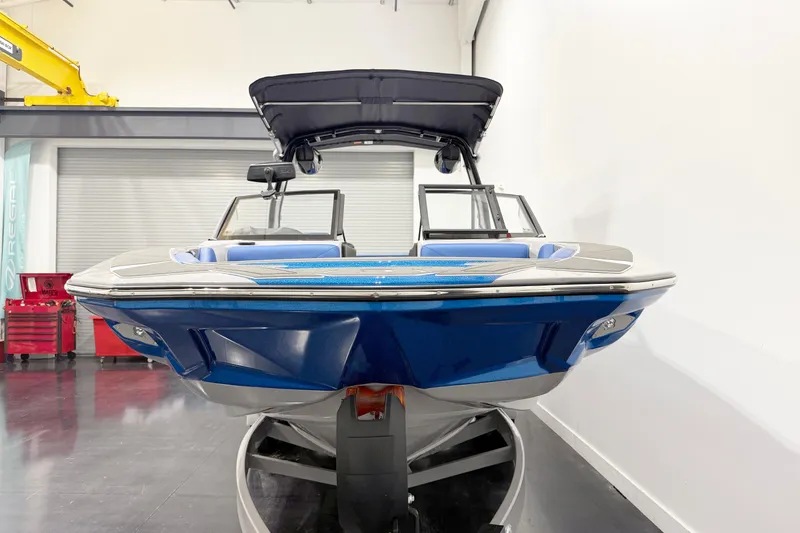Slide: The Image of 2025 Centurion Nv233 boat in showroom, blue exterior, sleek design, modern features. - 5