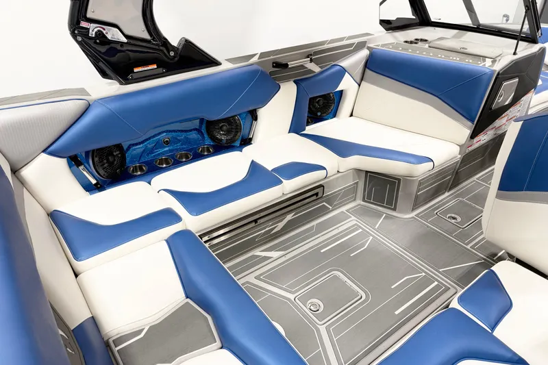 Slide: The Image of 2025 Centurion Nv233 boat interior with blue and white seating, modern design, and advanced audio system. - 7