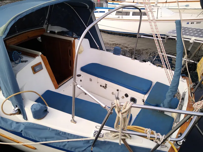 Slide: The Image of 1988 Pacific Seacraft Dana 24 sailboat with blue cushions in harbor. - 9