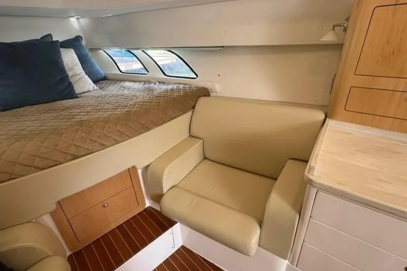 Slide: The Image of Interior of 2019 Intrepid 430 Sport Yacht with bed, seating, and wooden cabinetry. - 10