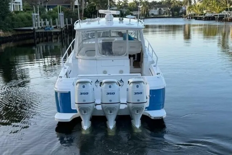 Slide: The Image of 2019 Intrepid 430 Sport Yacht with triple 350 horsepower engines on a calm waterway. - 18