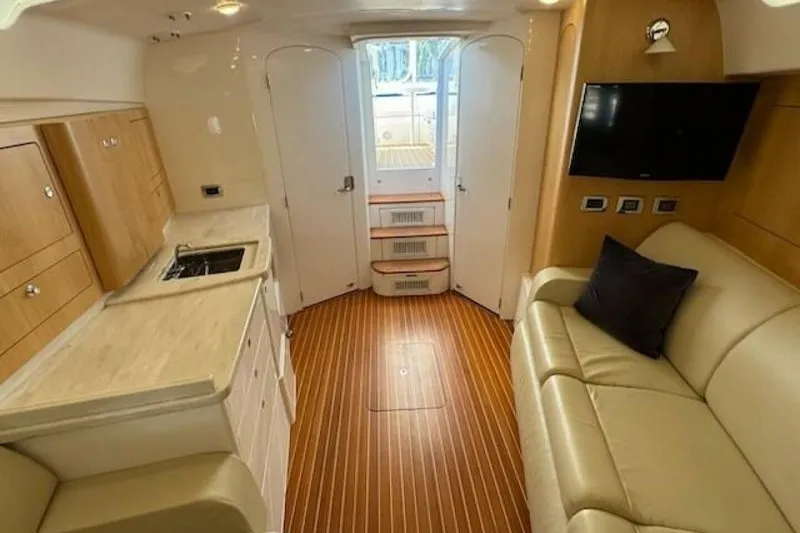Slide: The Image of Interior of 2019 Intrepid 430 Sport Yacht with kitchenette, sofa, and TV. - 6