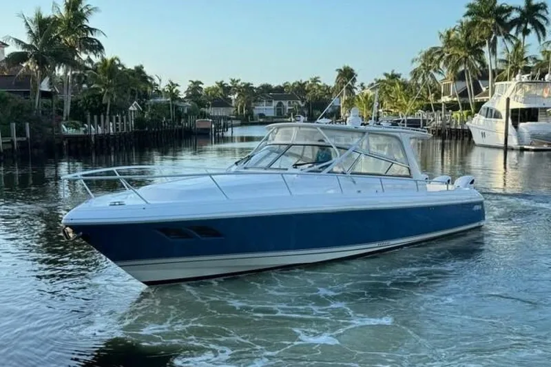 Slide: The Image of 2019 Intrepid 430 Sport Yacht cruising on a scenic waterway with palm trees. - 8