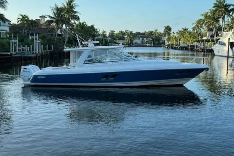 Slide: The Image of 2019 Intrepid 430 Sport Yacht on calm water, surrounded by palm trees. - 9