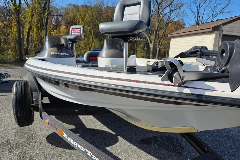 Slide: The Image of 1997 Ranger 462VS boat on trailer, parked outdoors, with trees in the background. - 6
