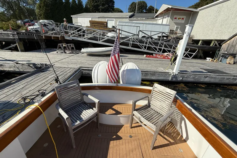 Slide: The Image of Boat deck with wooden chairs, American flag, dockside view; Black Horse 29, 2013 model. - 5