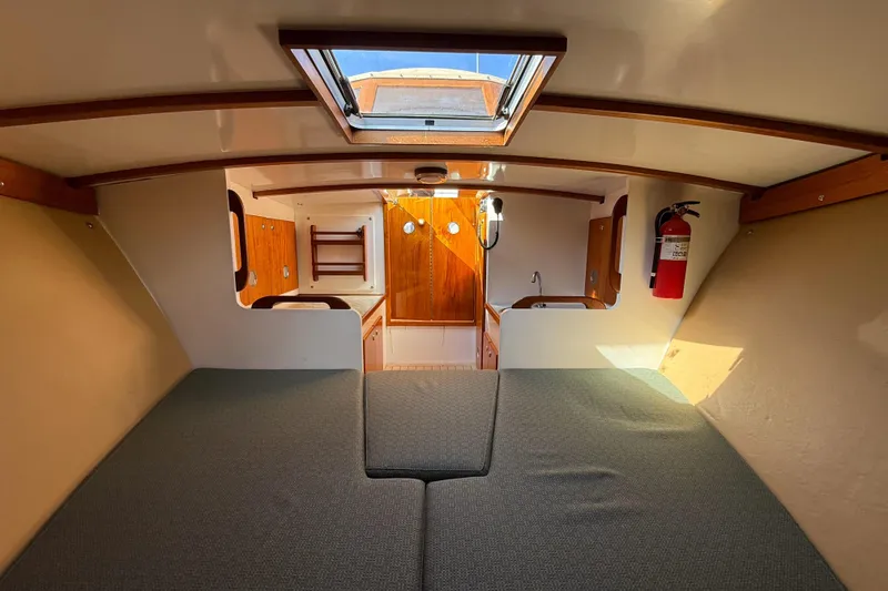 Slide: The Image of Cozy interior of 2013 Black Horse 29 boat with bed, wooden accents, and skylight. - 8