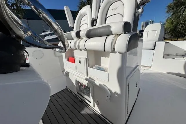 Slide: The Image of 2015 Tidewater 280 CC Adventure boat interior with dual cushioned seats and storage compartments. - 18