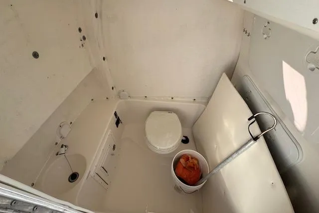 Slide: The Image of 2015 Tidewater 280 CC Adventure boat interior with toilet and storage area. - 19