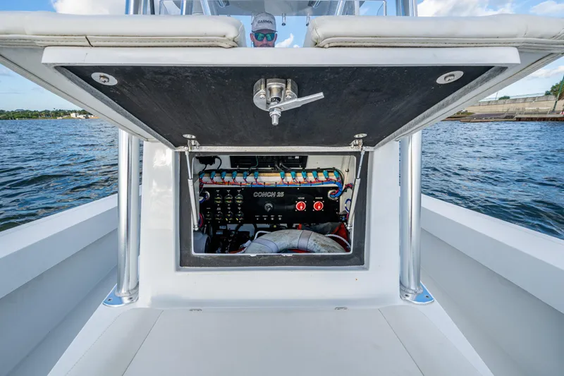 Slide: The Image of 2022 Conch 25 boat electrical panel open on deck, with water view. - 10