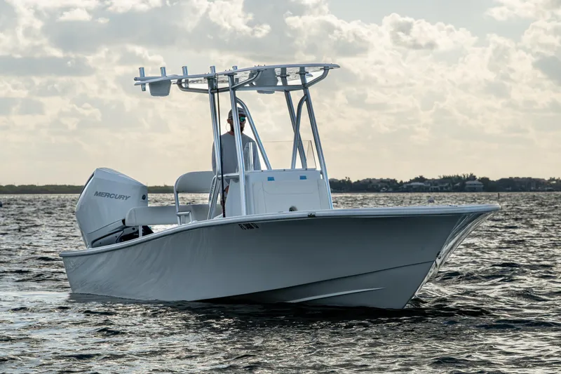 Slide: The Image of 2022 Conch 25 boat on water with Mercury engine, under cloudy sky. - 3