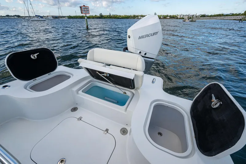 Slide: The Image of 2022 Conch 25 boat with Mercury engine, open storage compartments, and scenic water view. - 5