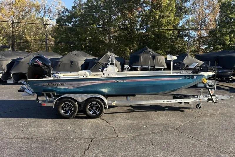 Slide: The Image of 2024 Ranger RB200 boat on trailer, parked outdoors with covered boats in background. - 7