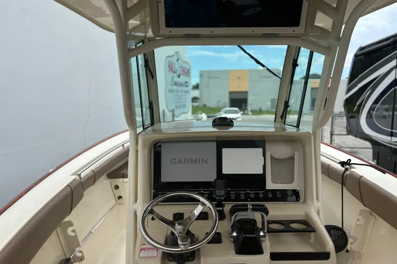 Slide: The Image of 2013 Scout 275 LXF boat helm with Garmin navigation system and steering wheel. - 13