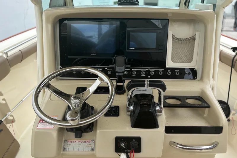 Slide: The Image of 2013 Scout 275 LXF boat dashboard with steering wheel and Garmin navigation system. - 14