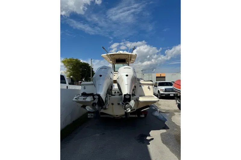 Slide: The Image of 2013 Scout 275 LXF boat with dual outboard engines in a parking area. - 7
