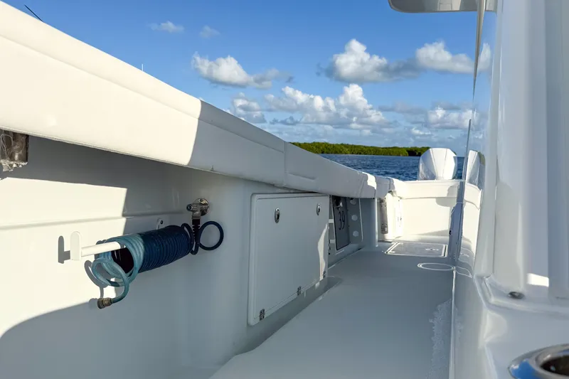 Slide: The Image of 2022 Yellowfin 39 Offshore boat deck with coiled hose, sunny day, blue sky. - 17