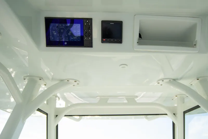 Slide: The Image of 2022 Yellowfin 39 Offshore boat dashboard with electronic displays and storage compartment. - 28