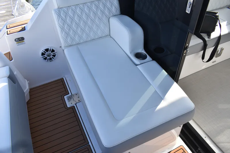 Slide: The Image of 2024 Regal 36 XO boat interior with white cushioned seating and cup holder. - 12
